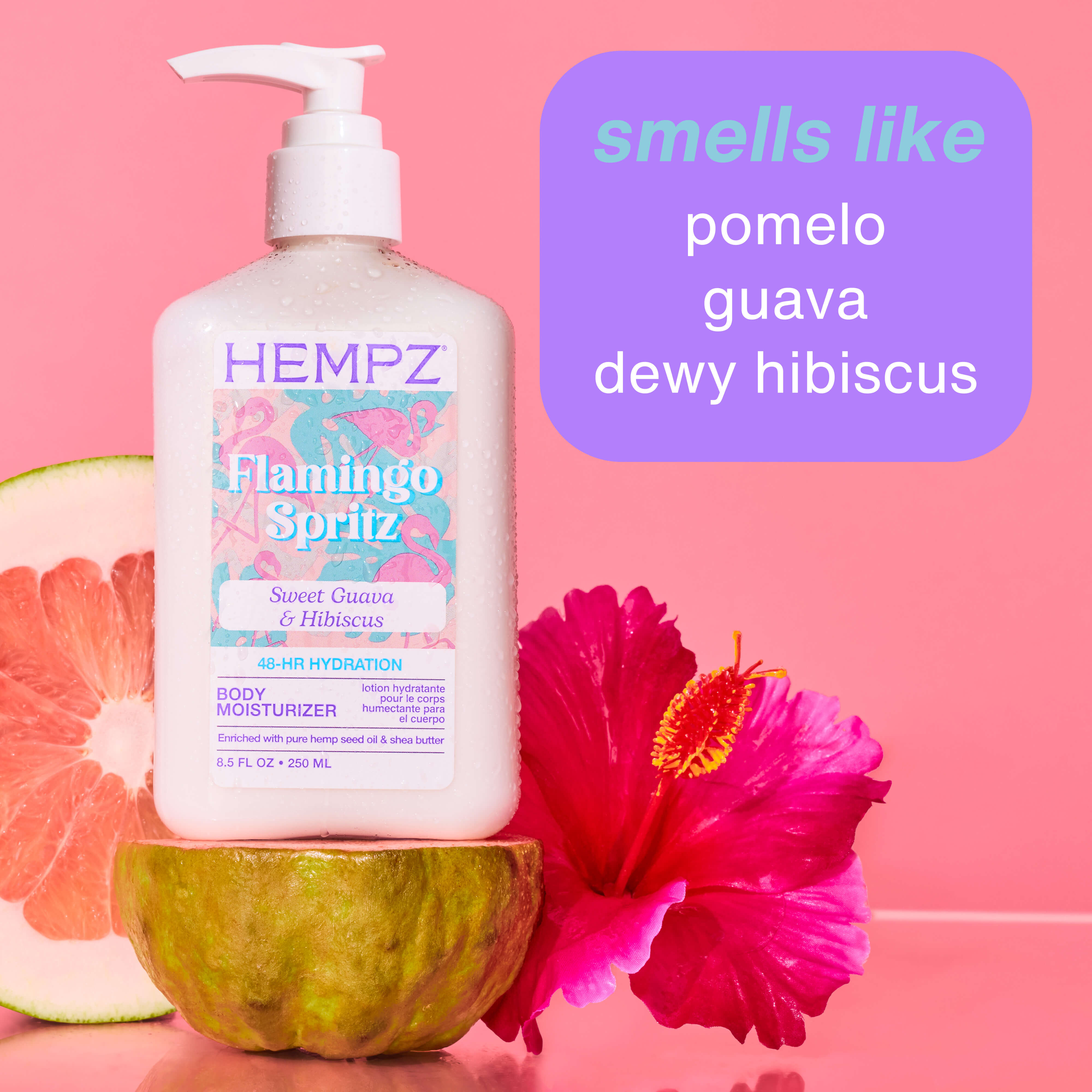 Hempz Flamingo Spritz body moisturizer bottle with pomelo, guava, and hibiscus elements on a pink background.