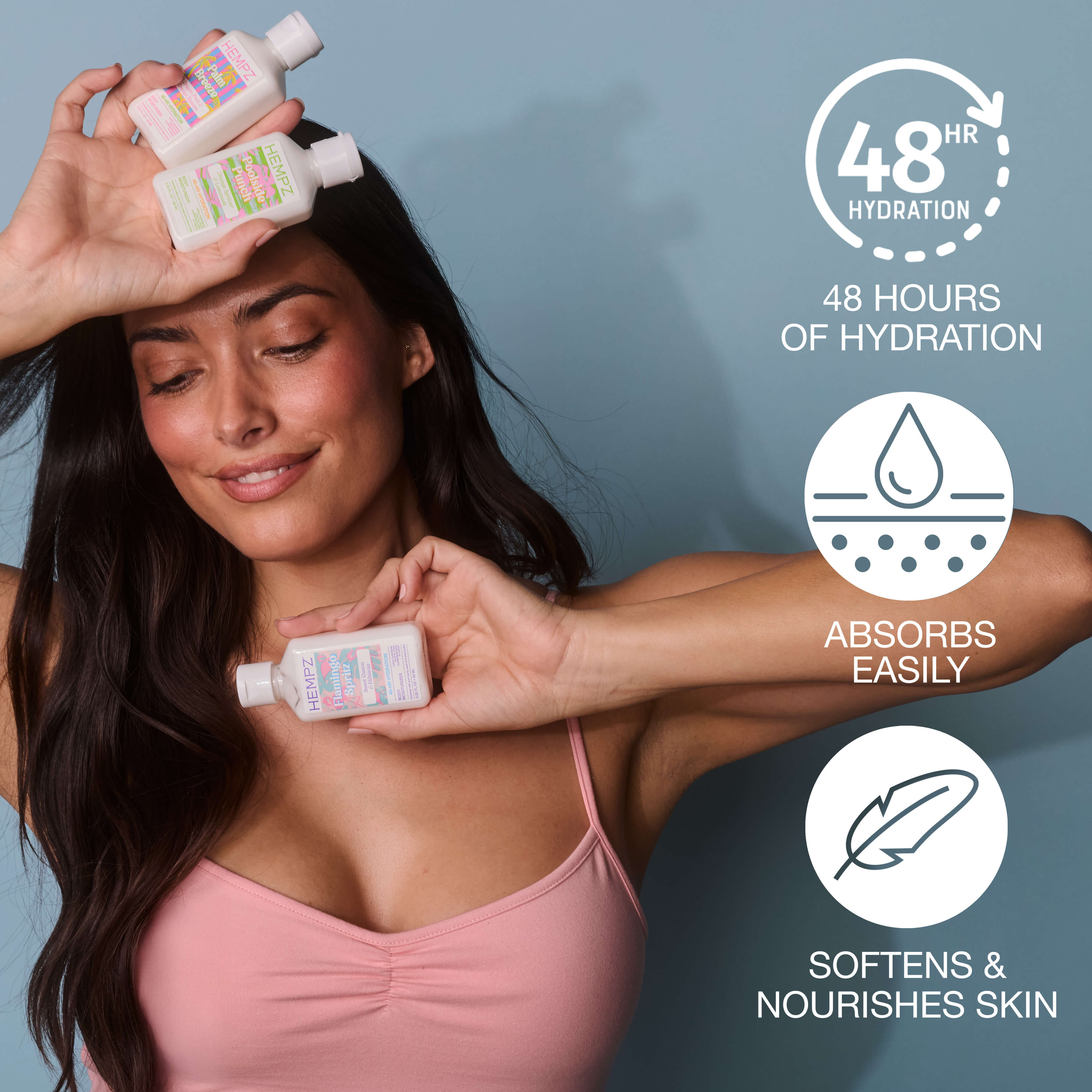 Woman holding Hempz Palm Springs mini lotion bottles of skincare product with text highlighting 48-hour hydration, easy absorption, and skin softening.
